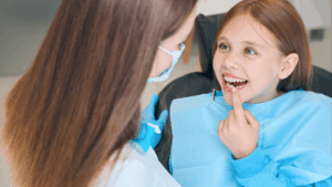 Girl shows her teeth to a woman a dentist